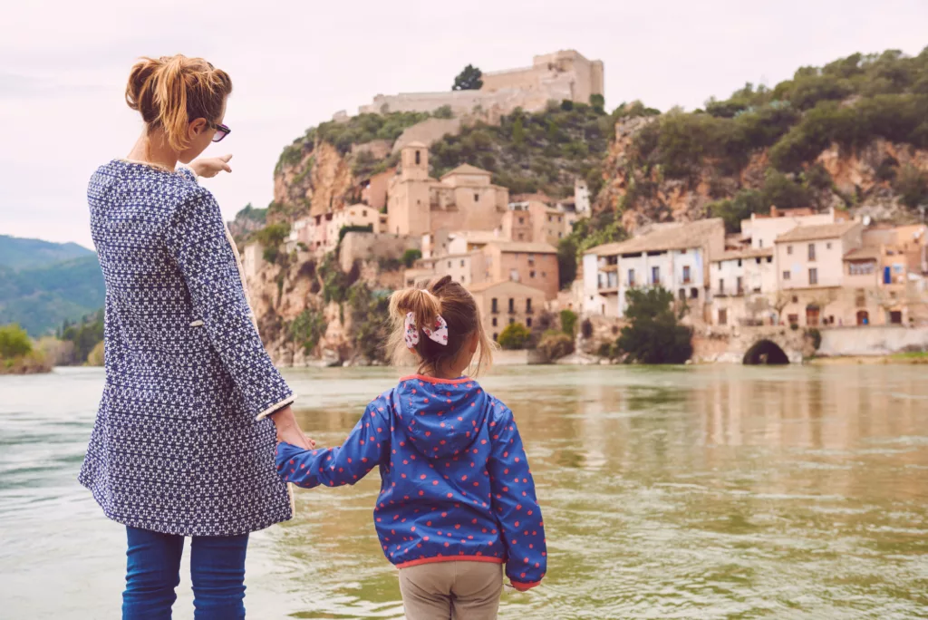 Mother and daughter travelers enjoying views of the Miravet village and Ebro river. Province of Tarragona. Spain