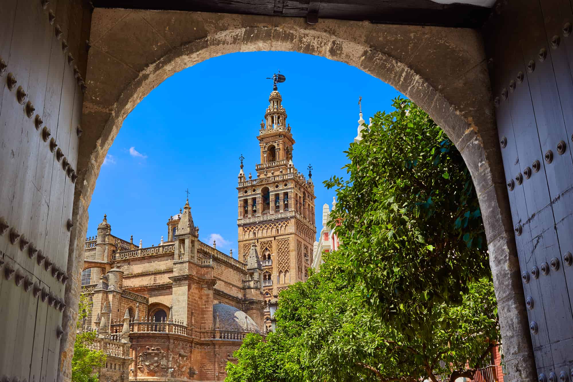 Seville cathedral Giralda tower from Alcazar arch door of Sevilla, Spain
