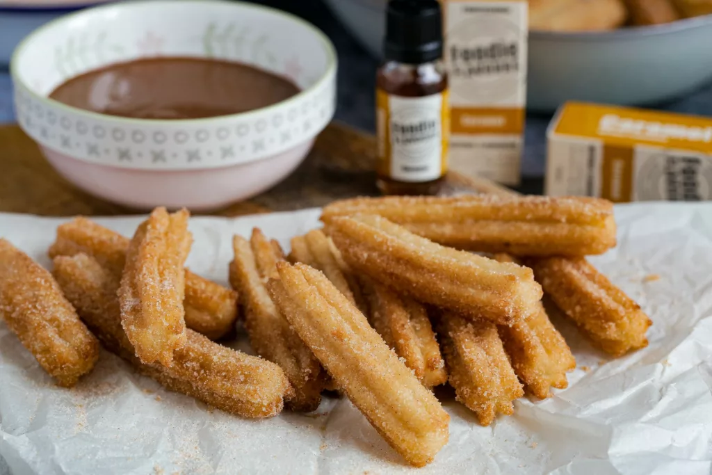 Churros with chocolate sauce in the background