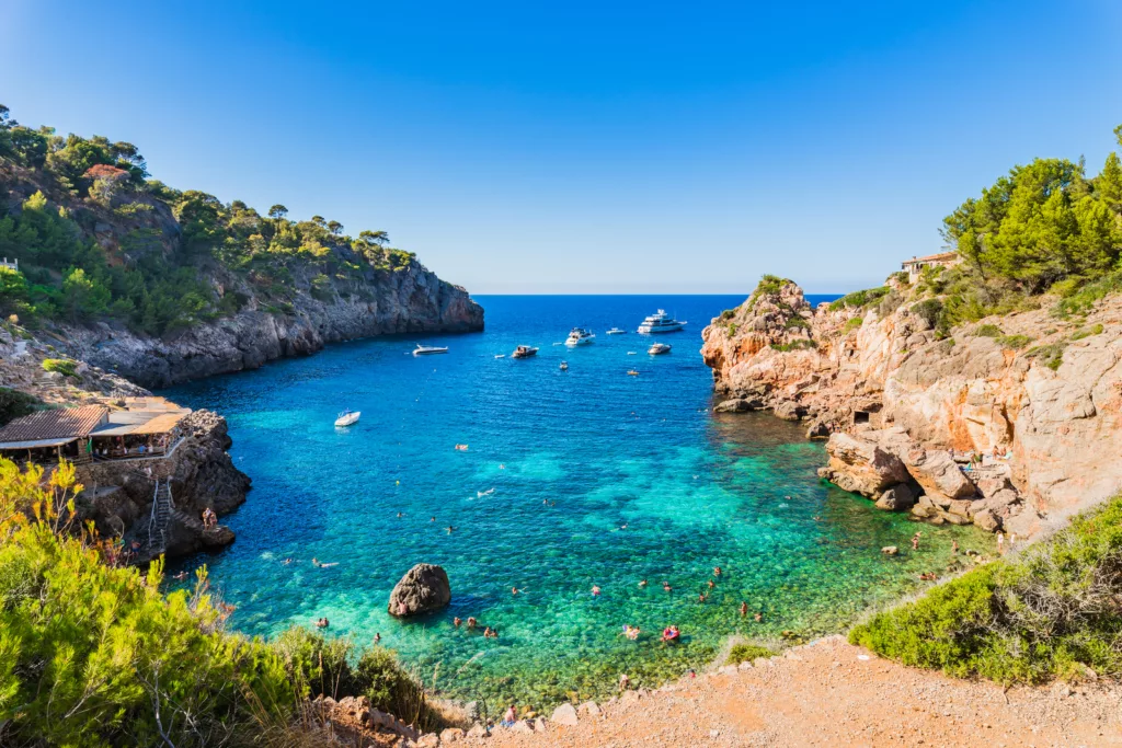 Sun-kissed sandy beach nestled in the scenic bay of Cala Deia, Majorca, Spain