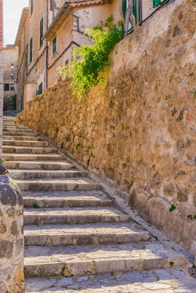Narrow stone-paved street in Deia, a charming mountain village on Mallorca.