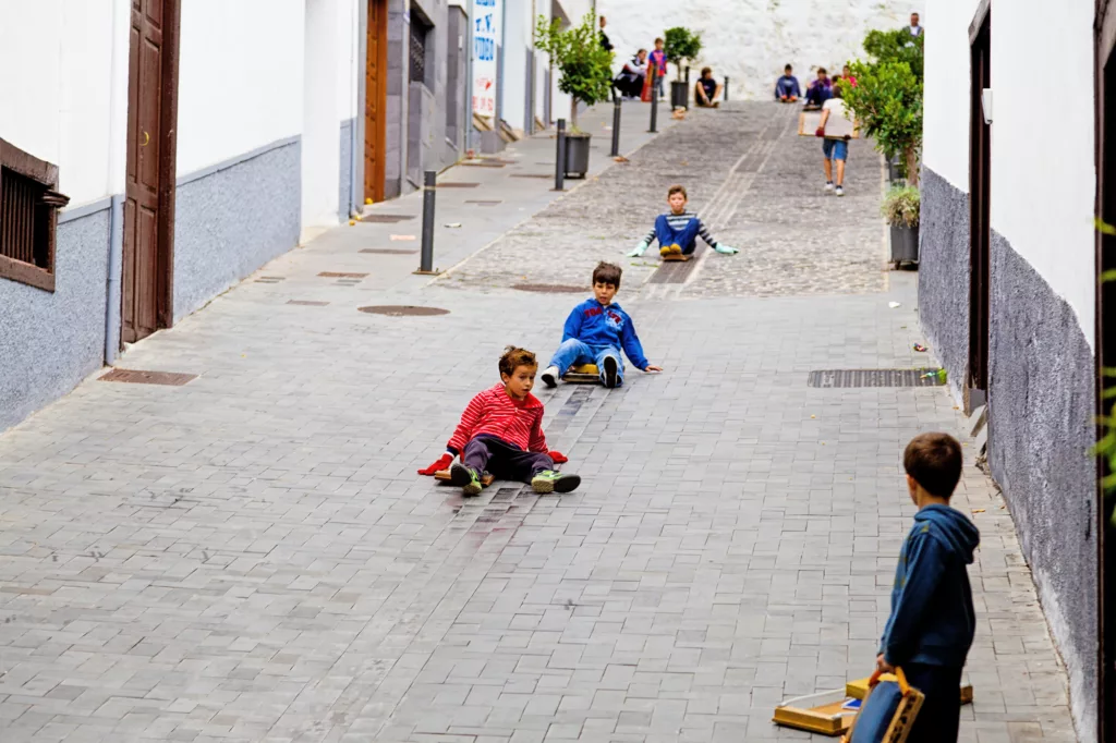 ICOD DE LOS VINOS, SPAIN - NOVEMBER 18: Childrens playing con wooden planks in the streets of Icod de los Vinos on November 18, 2012. Tradition feature in honor of San Andres of the municipalities of Icod and The Guancha on the island of Tenerife (Canary Islands). On the eve of San Andres locals flushed down some of the steepest streets of the towns mounted wooden boards.