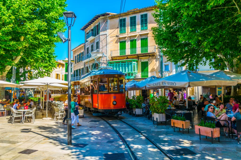 Traditional red tram is passing through the center of Soller in Mallorca