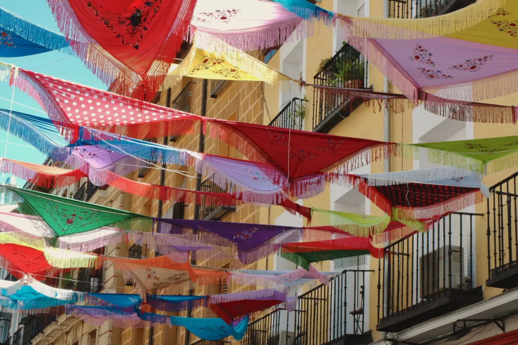 Classical Spanish shawls strung between the balconies outside on the street in La Latina district