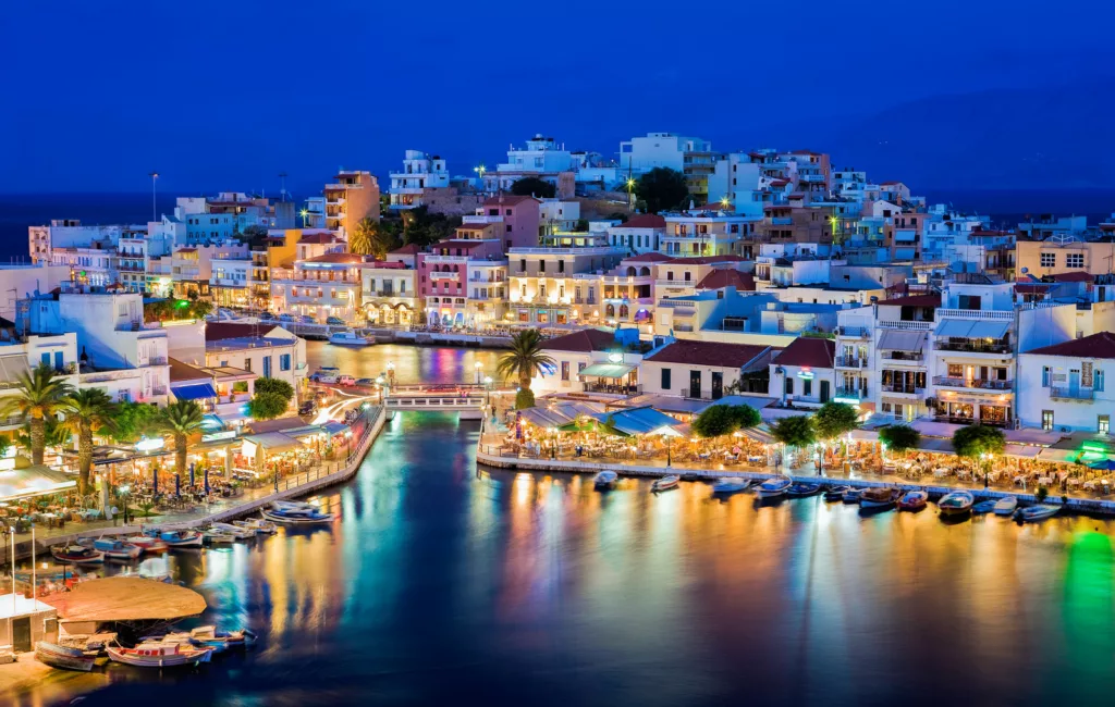 Agios Nikolaos. Agios Nikolaos is a picturesque town in the eastern part of the island Crete built on northwest side of the peaceful bay of Mirabello. Lake Vouliagmeni, Agios Nikolaos, Crete, Greece
