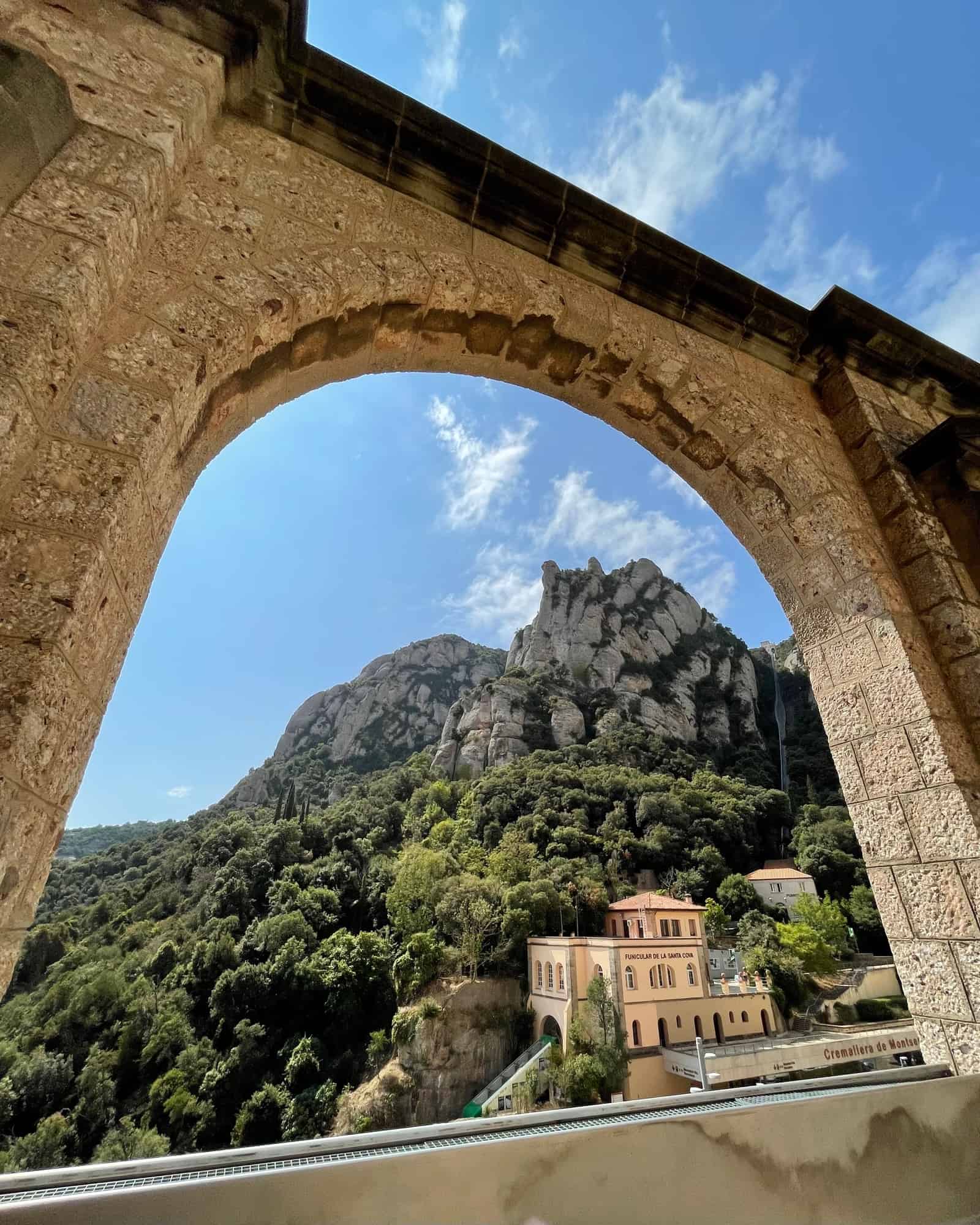 A beautiful view of the Montserrat mountain peak through the ruins of an arch building