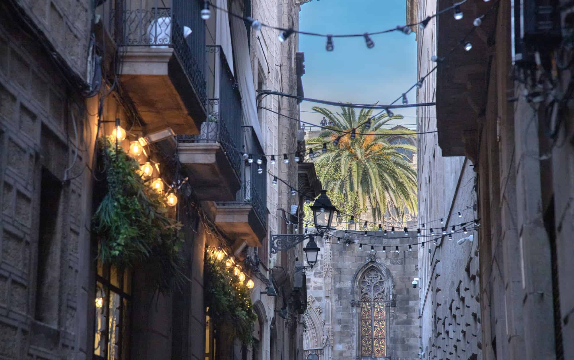 A low angle view of balconies on old buildings with lights in Born Area, Barcelona