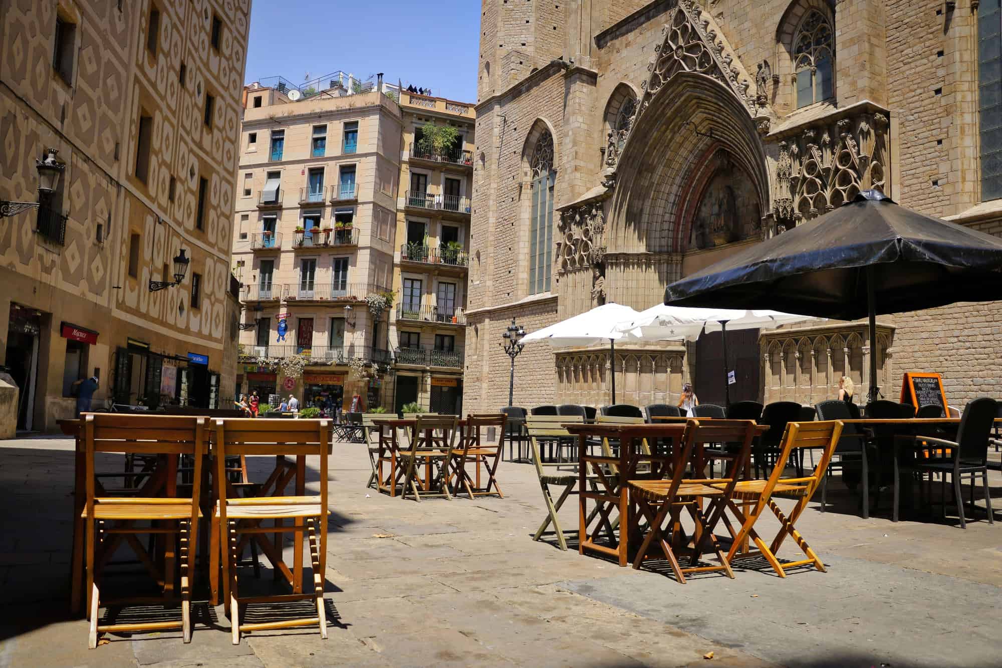 An empty outdoor cafe with wooden chairs and tables in the gothic quarter of Barcelona, Spain