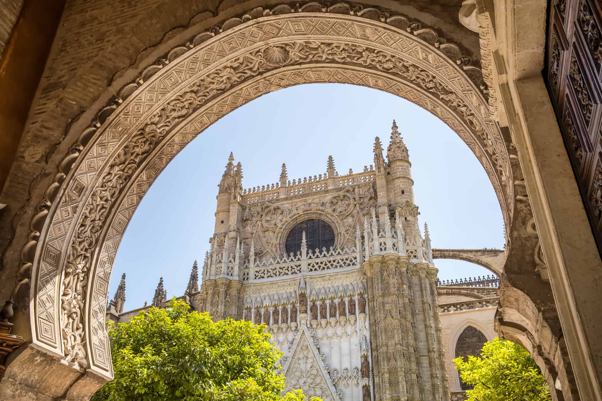 Cathedral of Seville seen through the carved arch in Sevilla, Andalucia, Spain