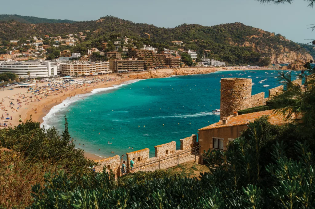 City walls of Tossa de Mar with the main beach Platja Gran in the background. Villa Vella