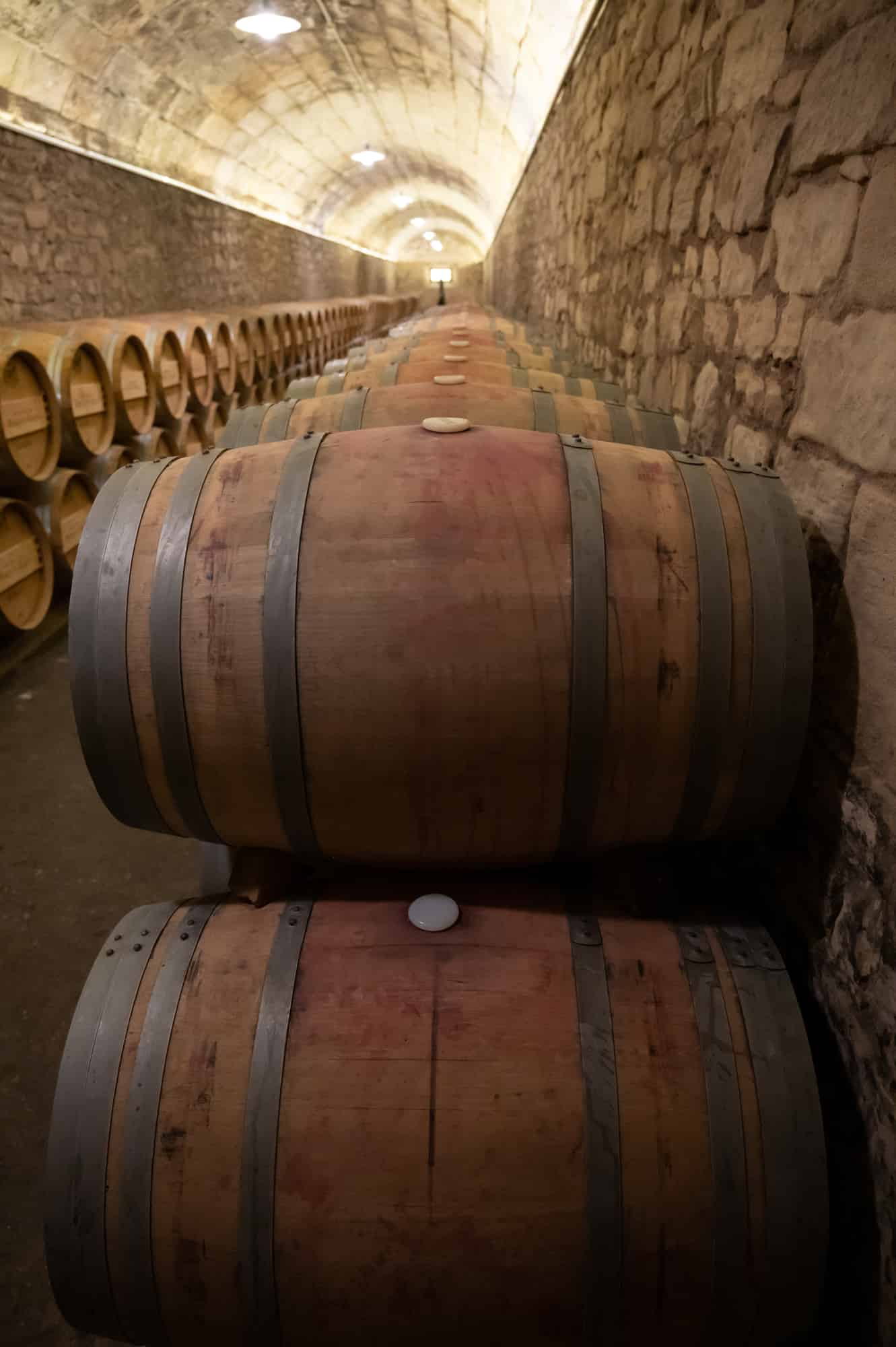 Old french oak wooden barrels in underground cellars for wine aging process, wine making in La Rioja region, Spain