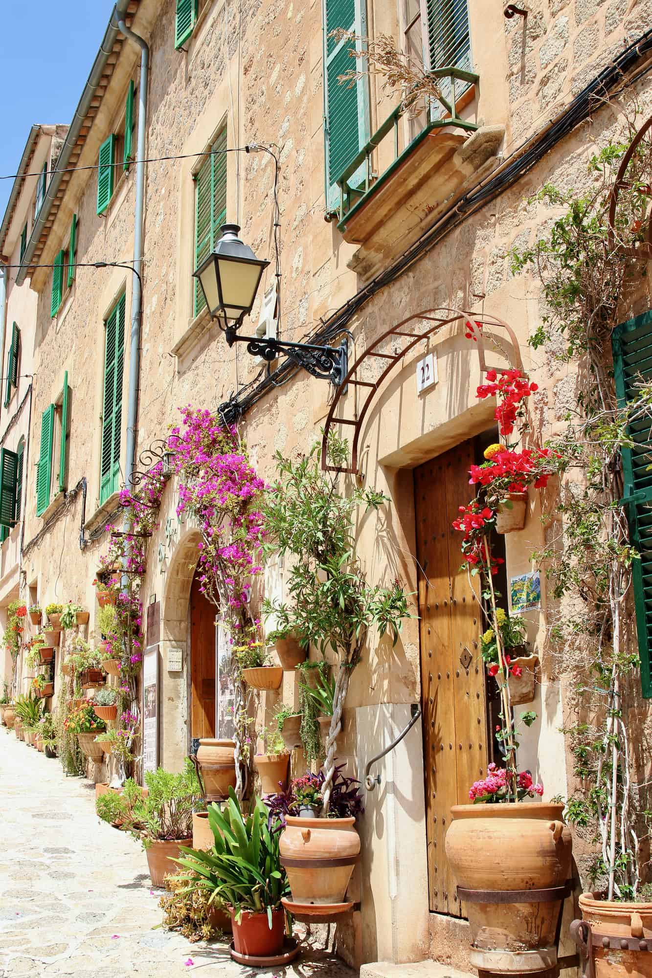 View of idyllic Valldemosa village old houses decorated with seasonal plants and flowers, Mallorca, Balearic Islands, Spain