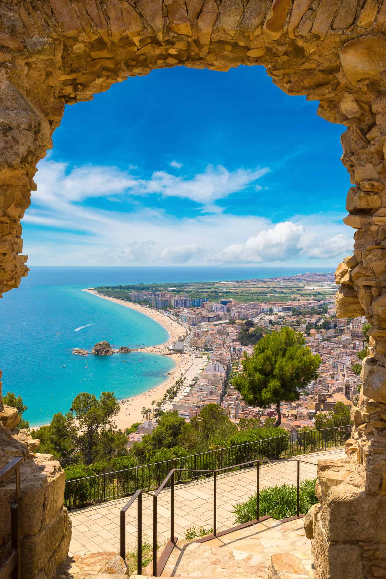 Blanes beach through a stone door of St. John Castle. Aerial panoramic view in Costa Brava in a beautiful summer day, Spain