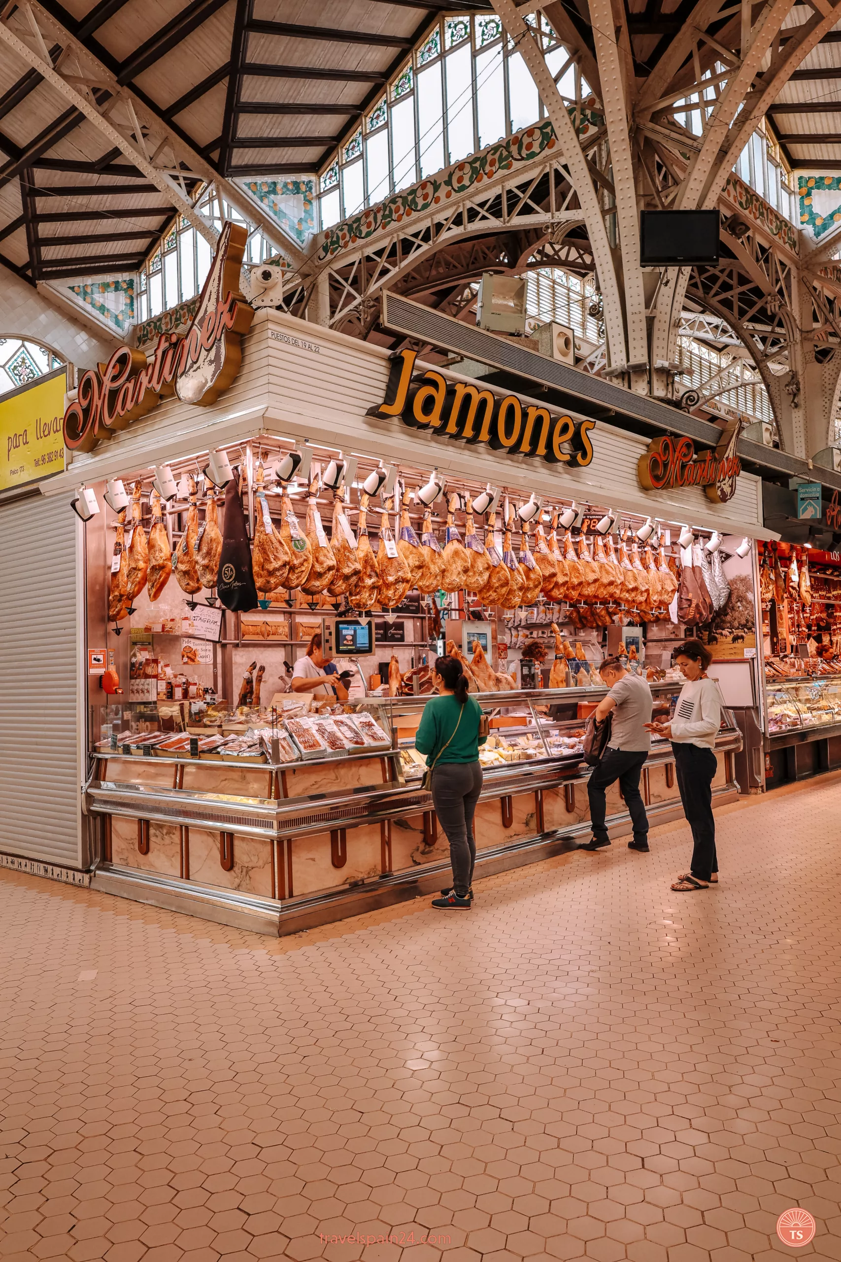 Traditional Spanish jamon varieties hanging in a row at Valencia market