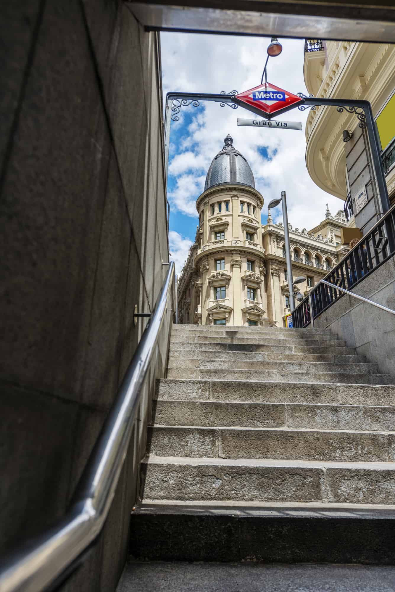 Madrid metro exit with stone stairs and metal railing at Gran Via station