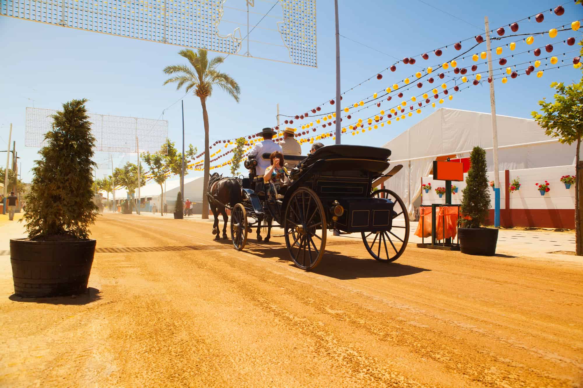 People in a horse carriage at the fair in Seville during March