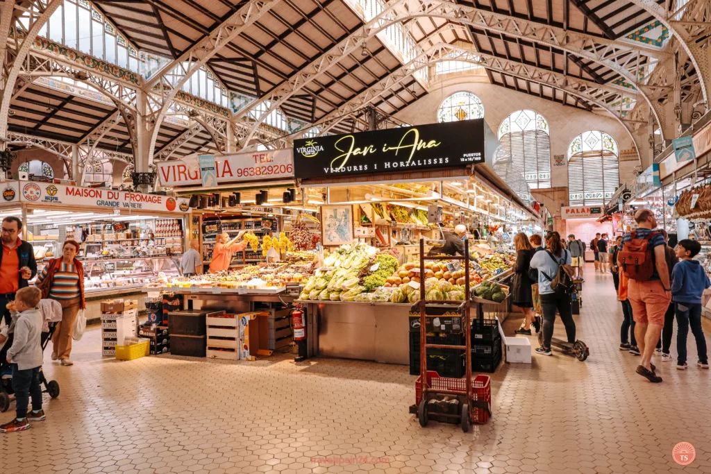 Valencia Central Market with many shops and a lively crowd, under a beautiful, high ceiling.