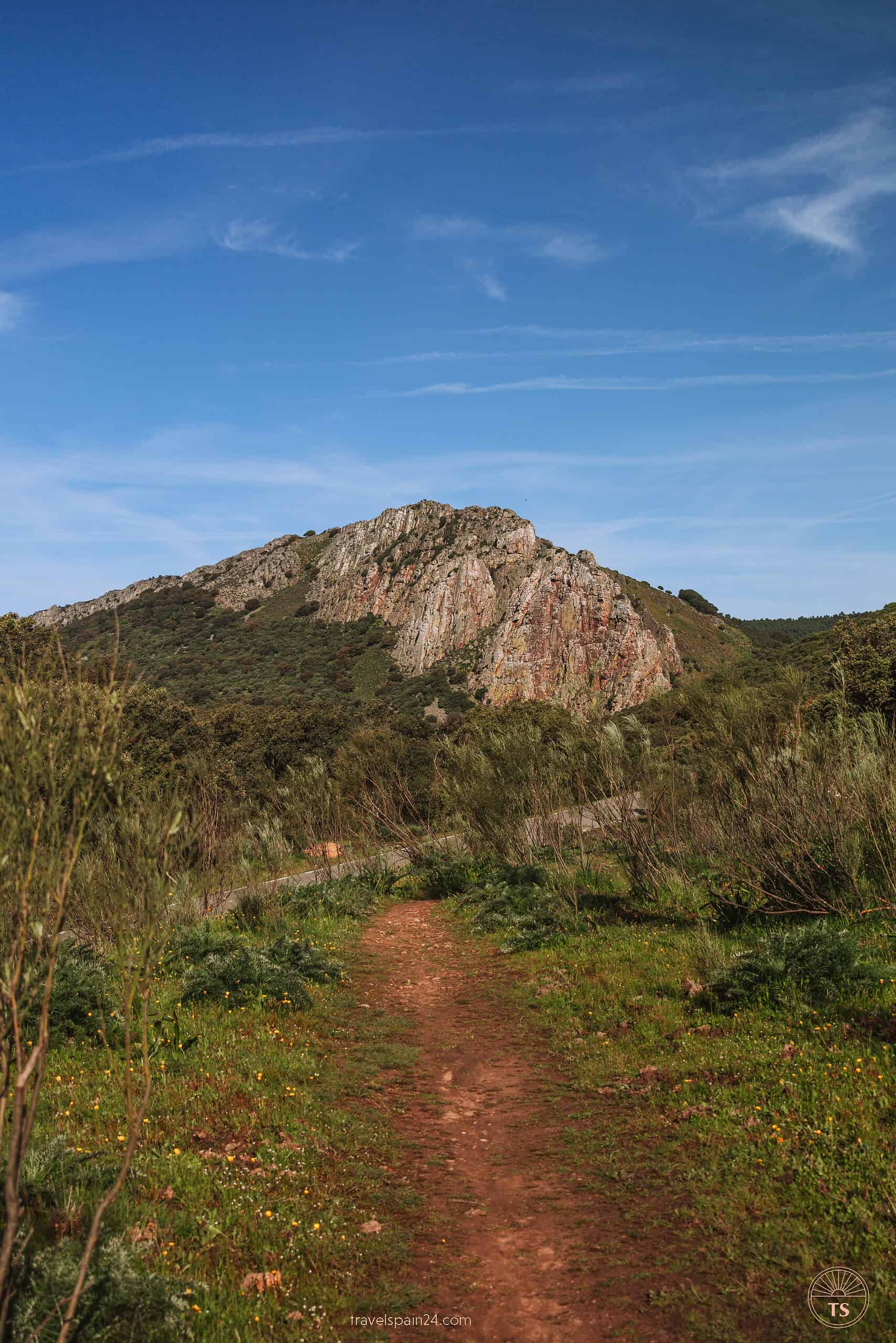 Road descending from the castle towards Salto del Gitano in Monfragüe, showcasing a key segment of the park's premier hiking trail.
