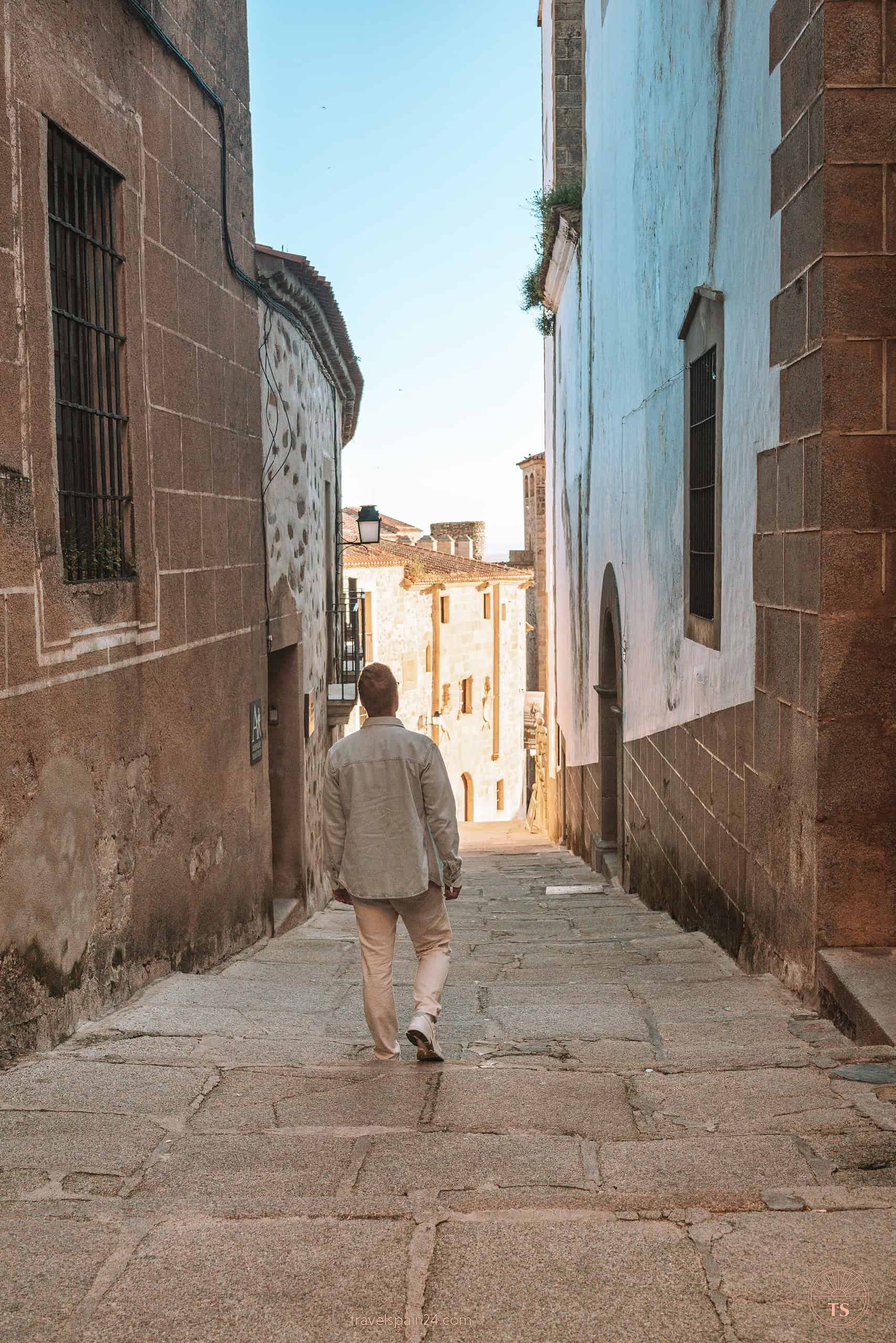 Timon van Basten descending old cobblestone stairs in the old town of Cáceres, capturing the essence of the city's ancient charm.