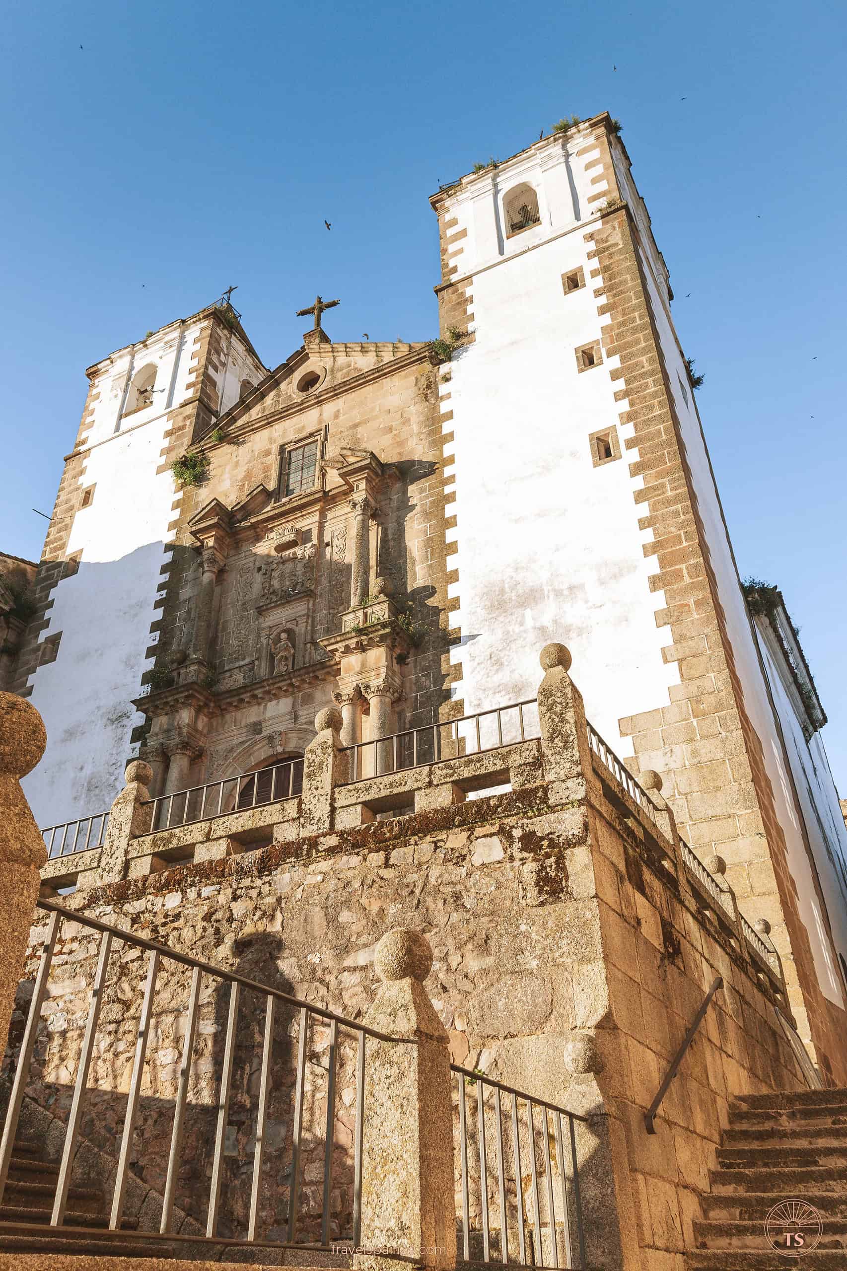Close-up of Iglesia de San Francisco Javier in Cáceres, featuring its distinctive white bell towers on either side of the building.