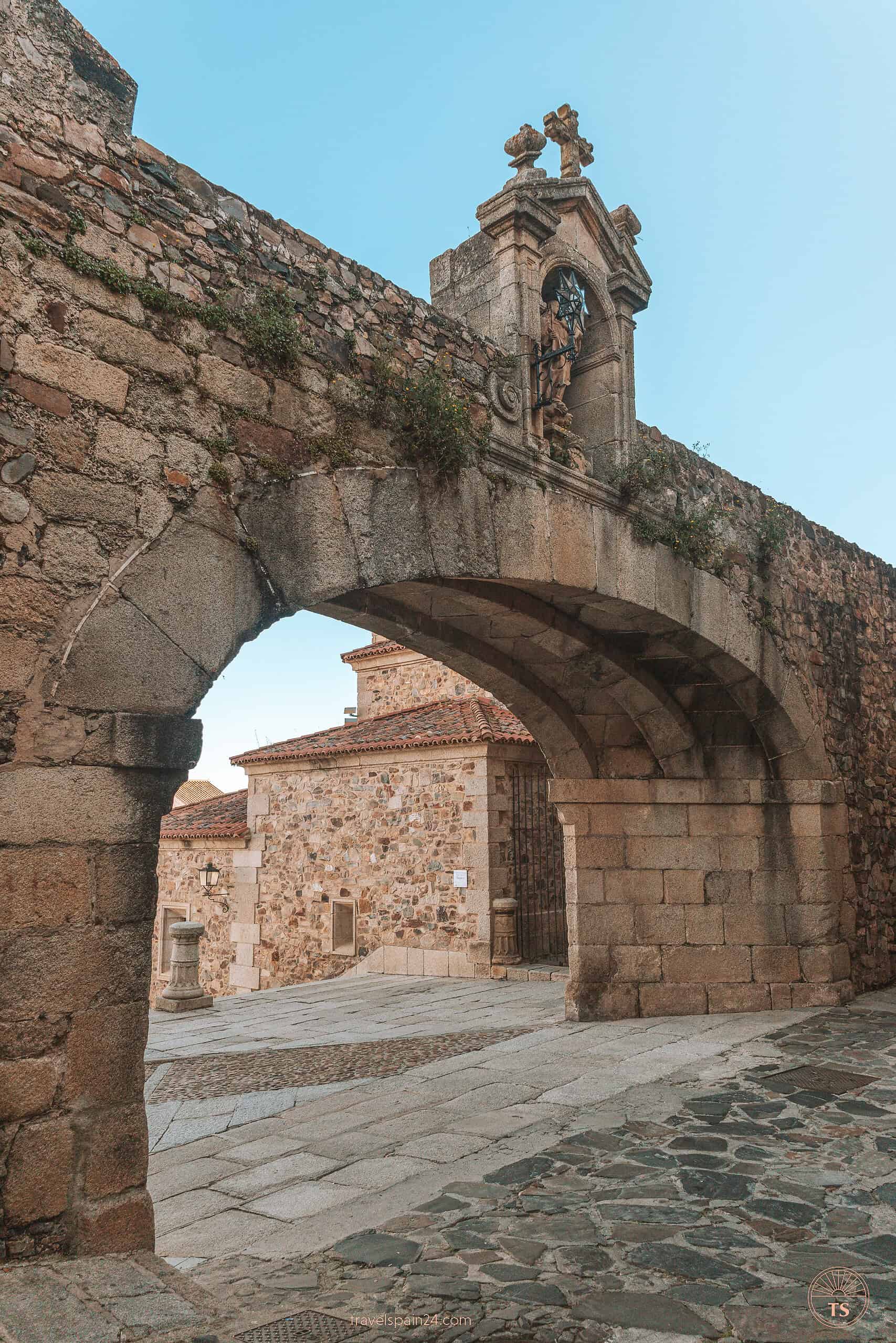 The majestic Arco de la Estrella framing our path as we enter the main square of Cáceres, a gateway to more discoveries.