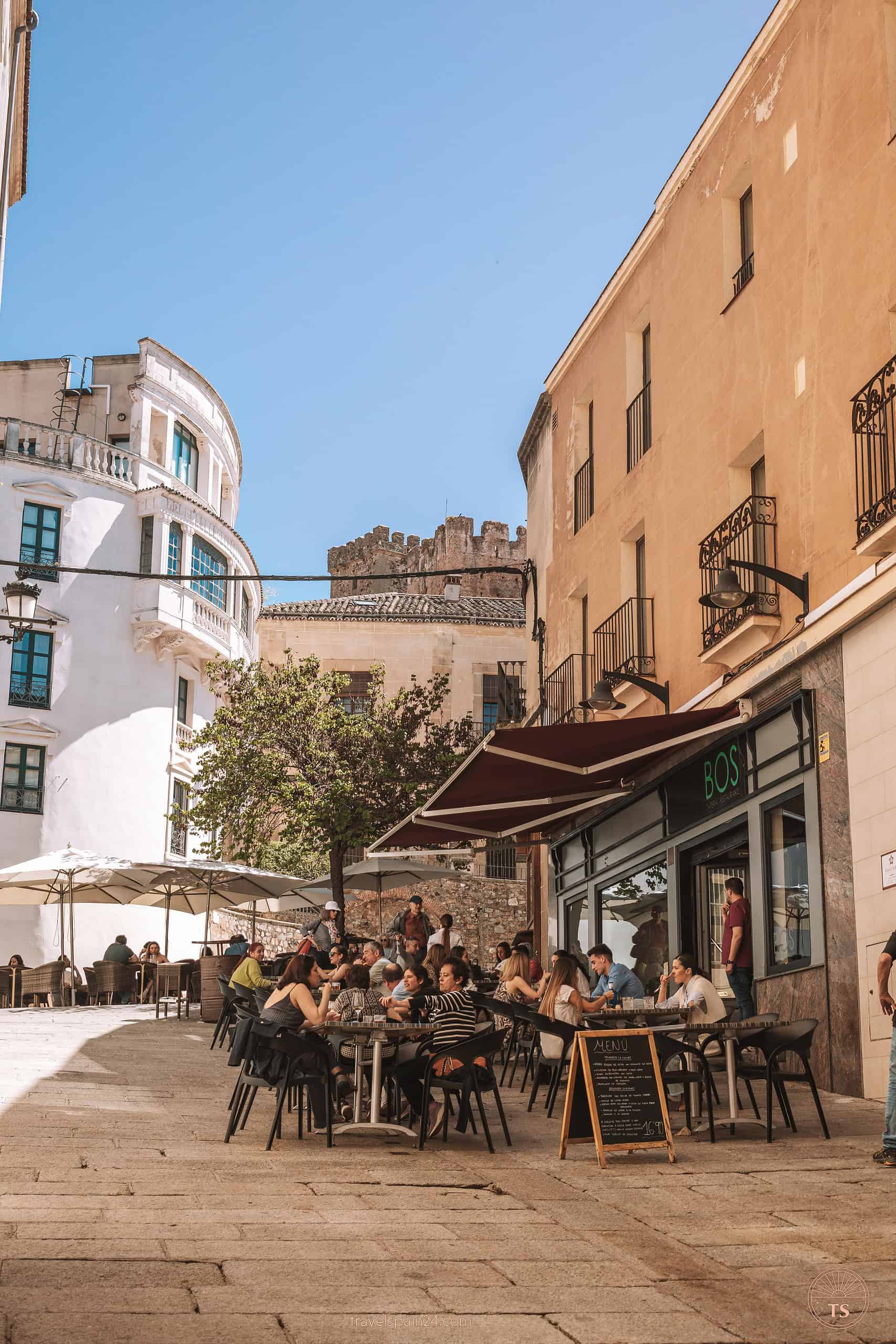 The bustling outside terrace of BOS Tapería-Restaurante in Cáceres, filled with guests enjoying Spanish tapas and Mediterranean dishes near Plaza Mayor.