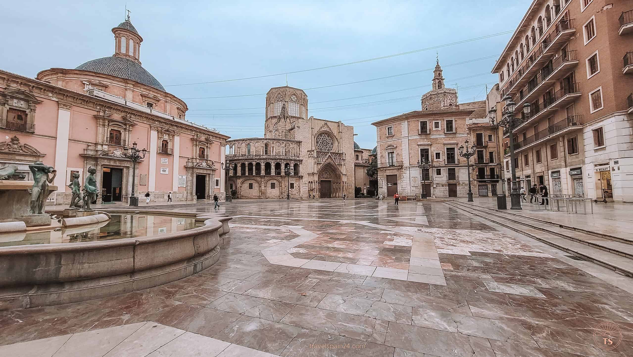 Early morning view of Plaza de la Virgen in Valencia, nearly empty and perfect for photography, with light clouds and the sun just starting to rise