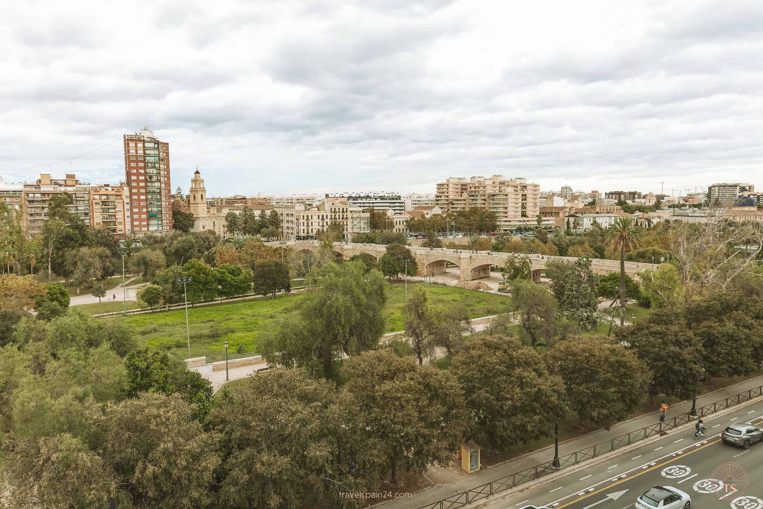 Panoramic view from the terrace of Blanq Carmen Hotel overlooking Turia Garden in Valencia, showcasing the lush park on a cloudy day, a peaceful retreat within the city.