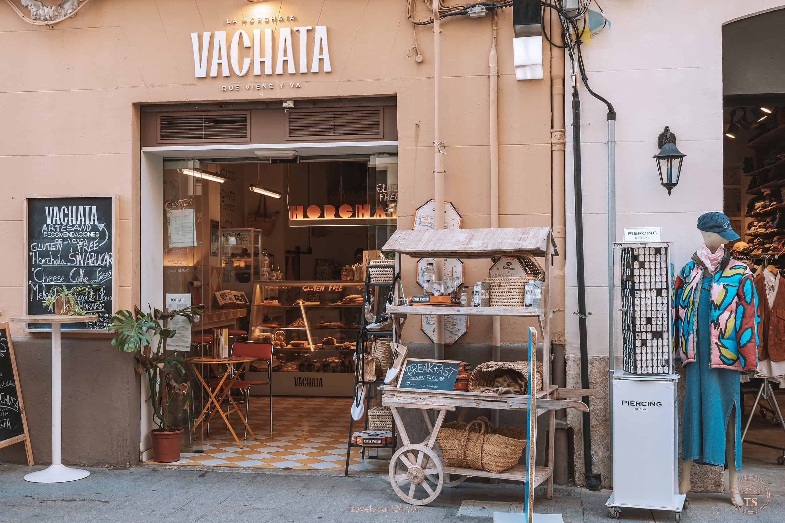 Front view of Vachata, a quaint small pastry shop in Valencia where visitors can buy sandwiches and cakes, inviting passersby to taste local treats.